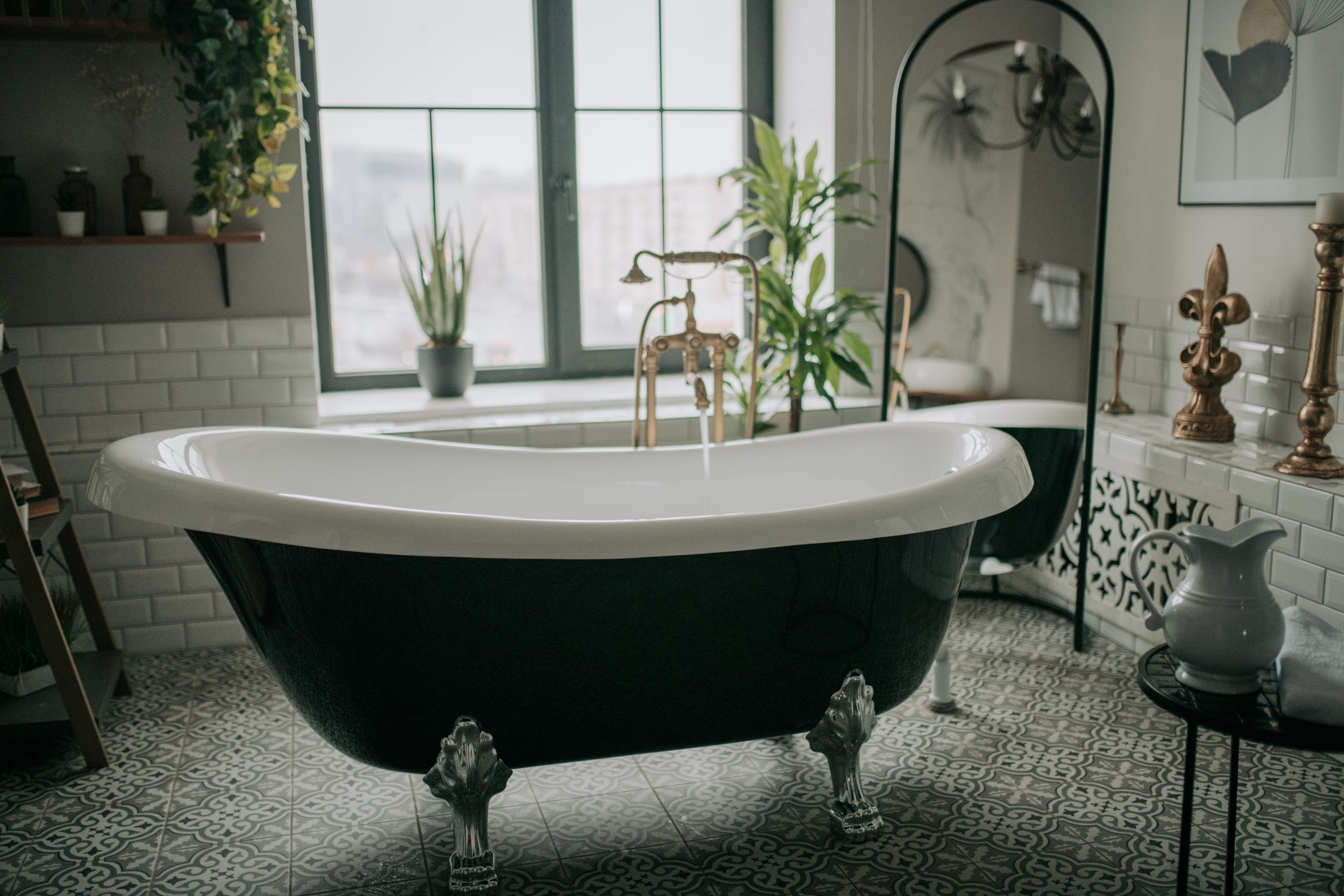 classic clawfoot tub with spanish tiles on the floor and subway tiled walls