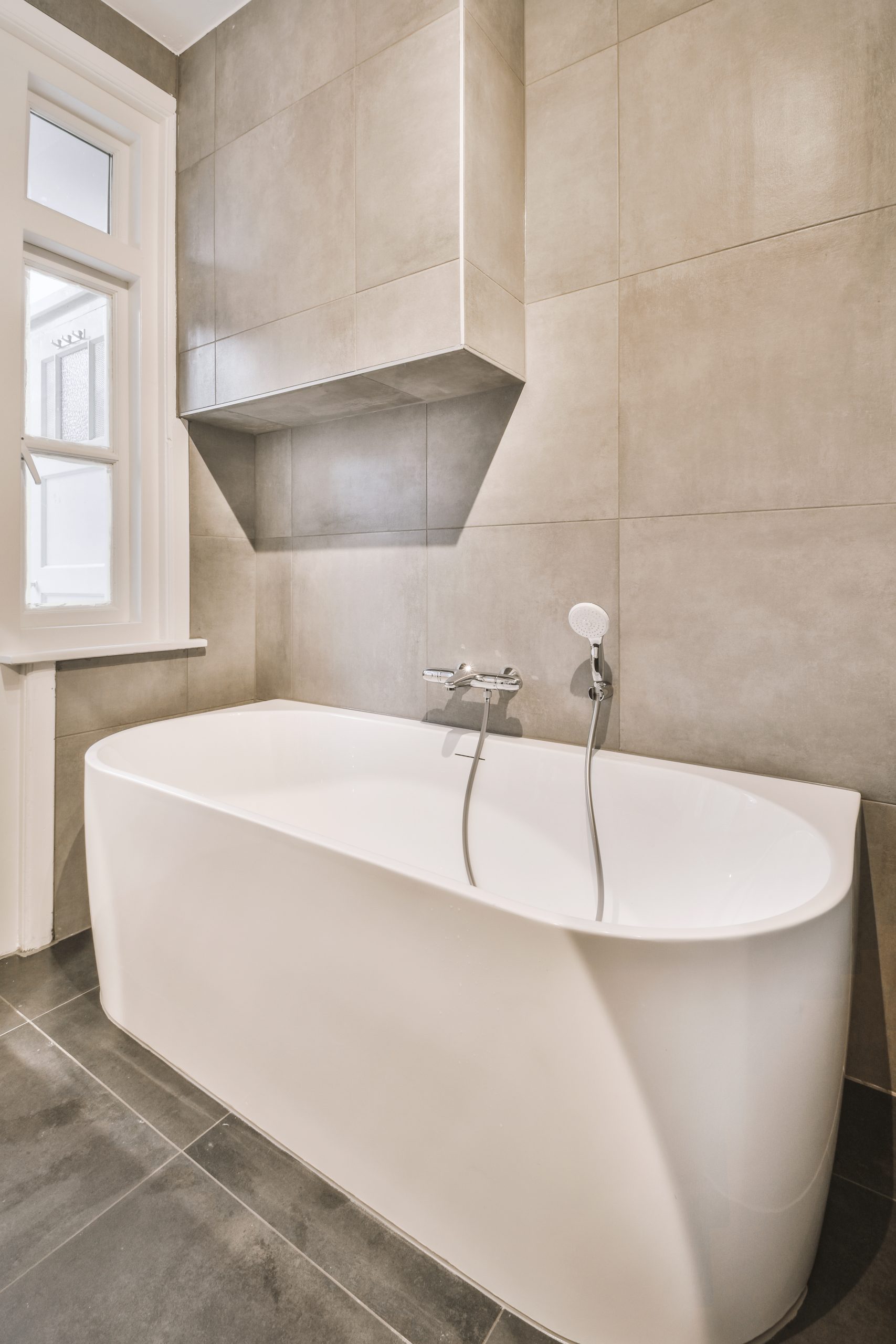 renovation included free standing tub, large tiles on wall and floor in Denver